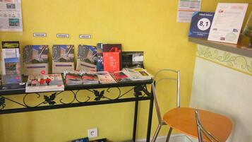 A reception desk with brochures and a guest review awards sign.