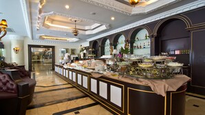 Een luxueuze hotellobby met een centraal gelegen bar, stijlvolle zitplaatsen en een decoratief plafond.