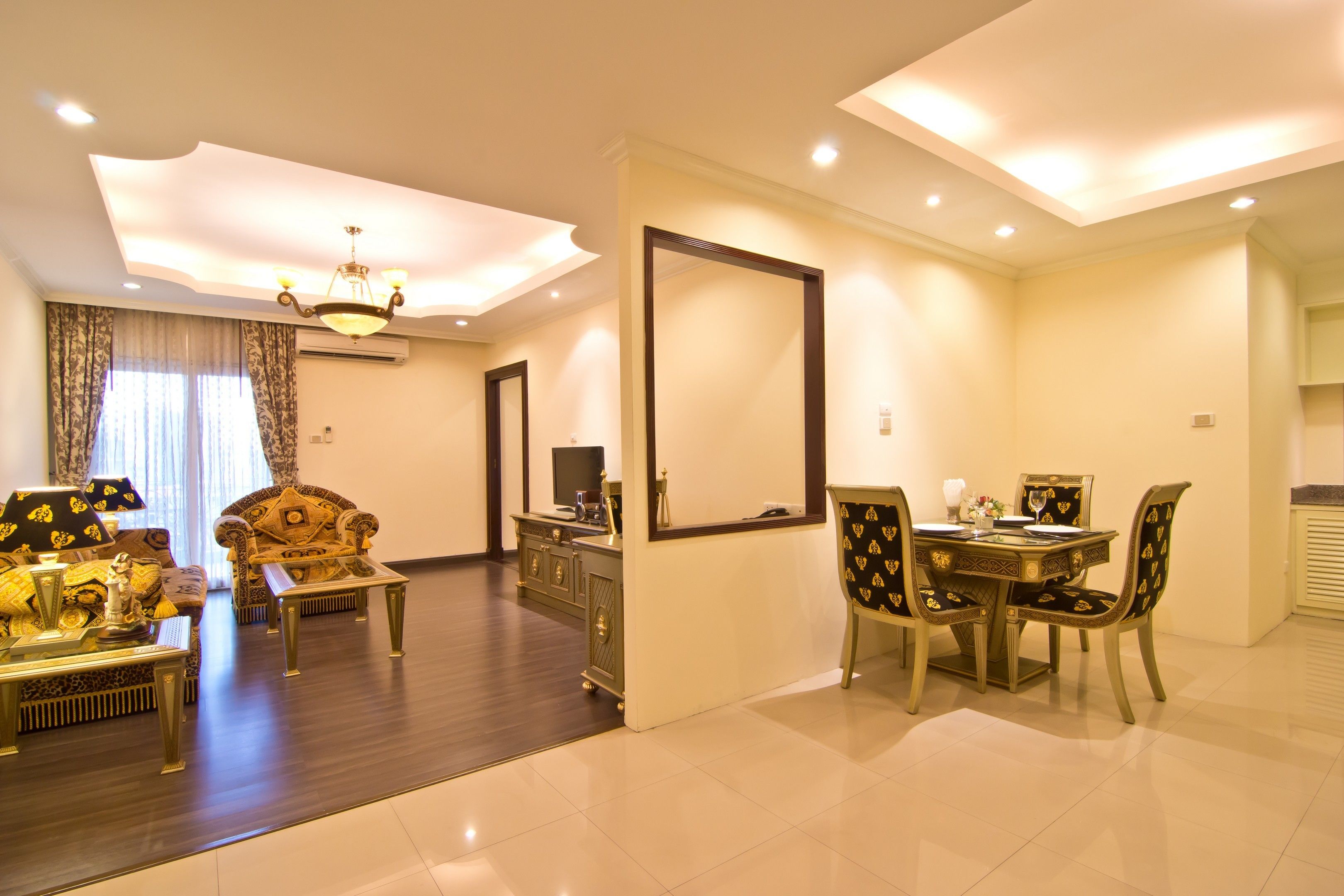 A spacious living room with a sofa, coffee table, and dining table set.