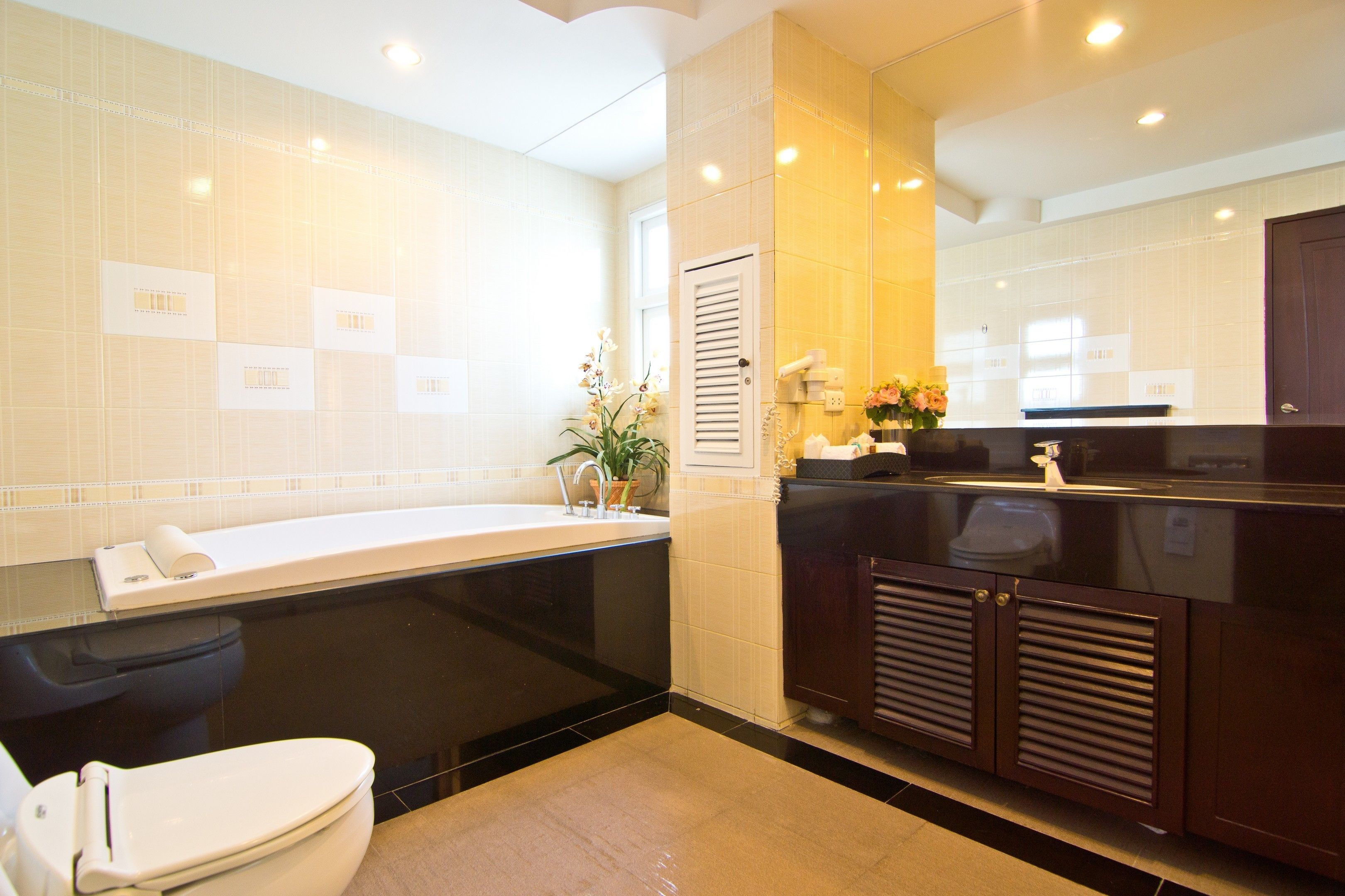 A modern bathroom with a bathtub, toilet, and vanity.