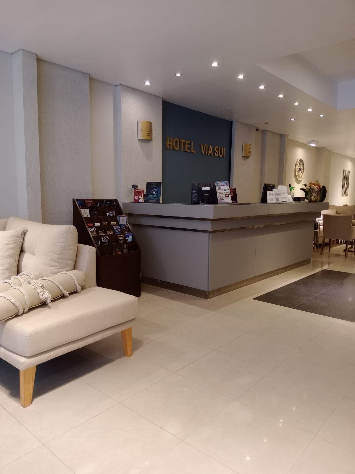 A hotel reception area with a reception desk, a sofa, and a coffee table.