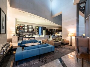 A spacious lobby with a seating area, a bar, and a well-lit reception desk. - Grand Mercure Ambassador Changwon (Changwon)