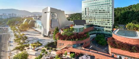 A modern building complex with a glass facade, a distinctive curved structure, and a central atrium.