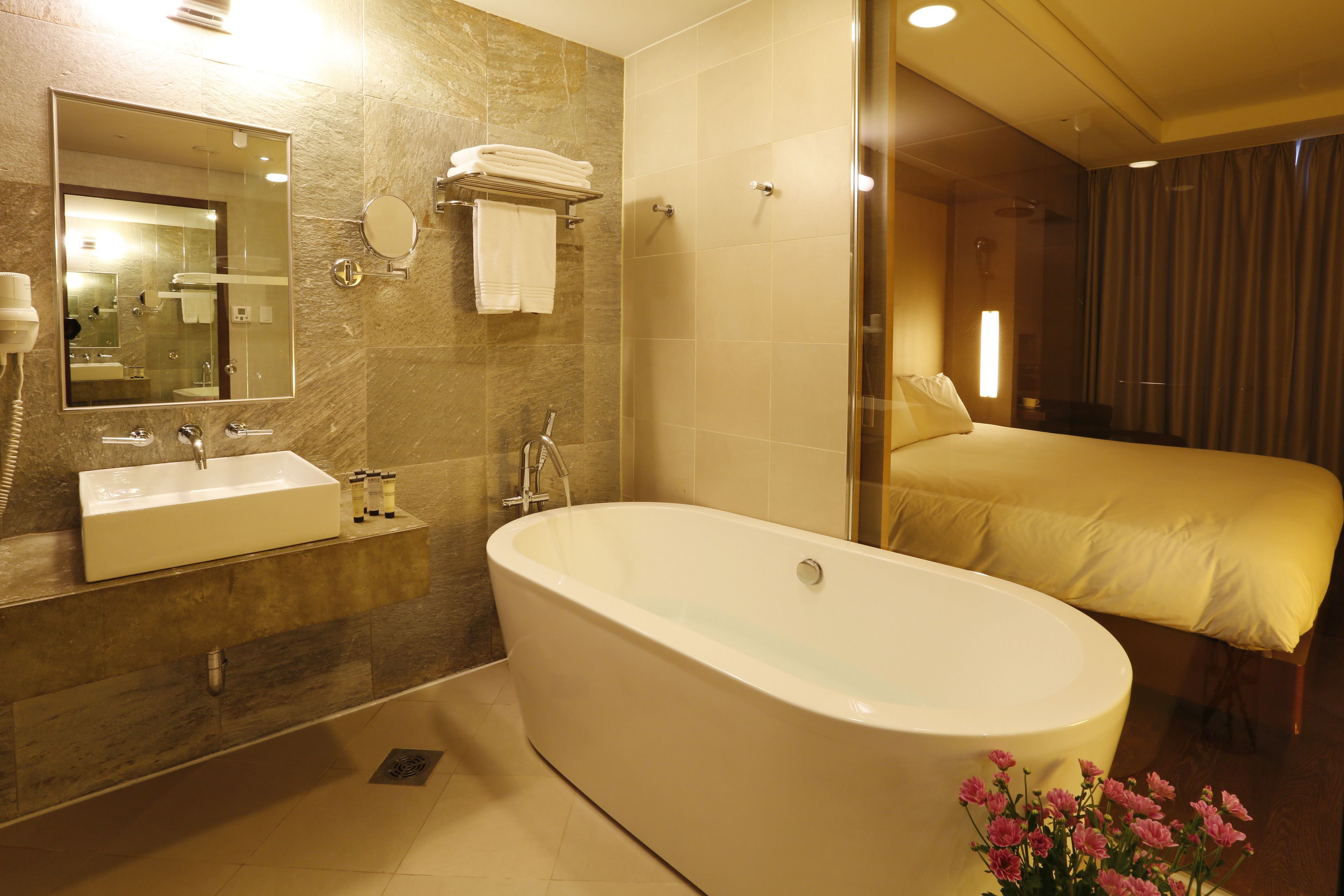 Ein modernes Badezimmer mit einer großen Badewanne, einem Doppelwaschbecken und einem Spiegel.
