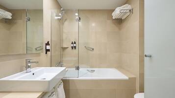 Un baño moderno con ducha acristalada, lavabo blanco y bañera.