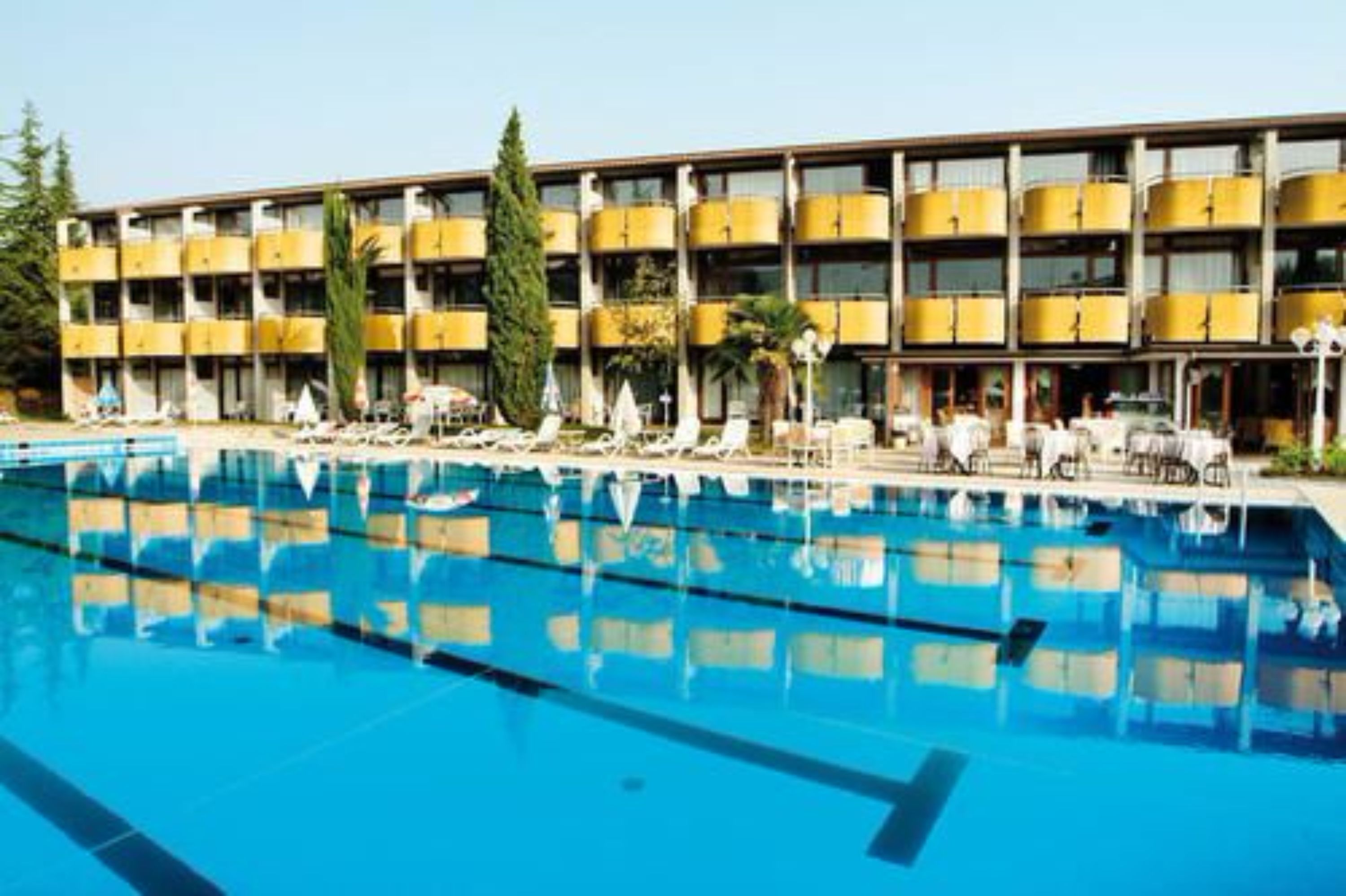 Un hôtel doté d’une piscine, de plusieurs balcons et de chaises longues.