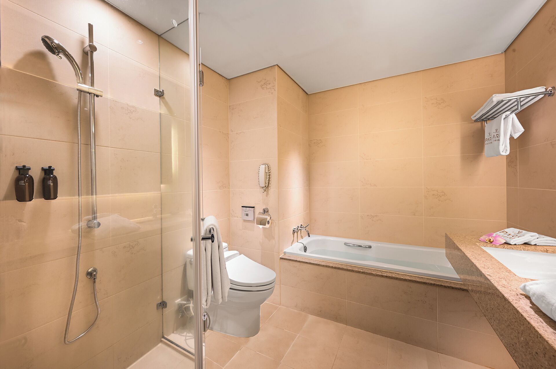 Une salle de bain moderne dotée d’une douche à parois de verre, de toilettes et d’une baignoire.