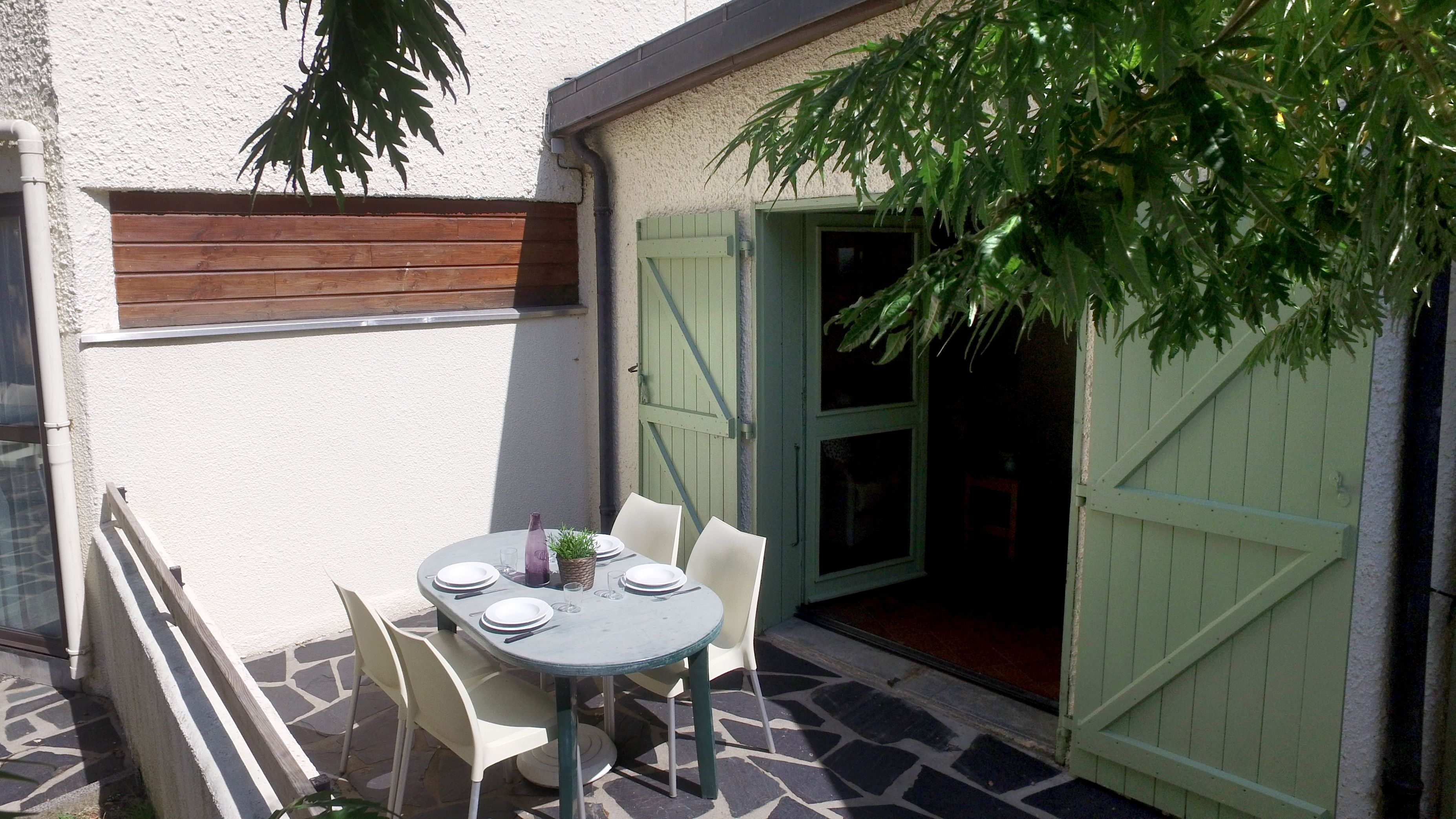 Eine Terrassengruppe im Freien mit einem runden Esstisch und Stühlen.