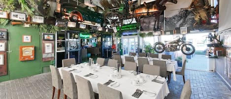 Un restaurante con una larga mesa de comedor lista para una comida, rodeada de sillas.