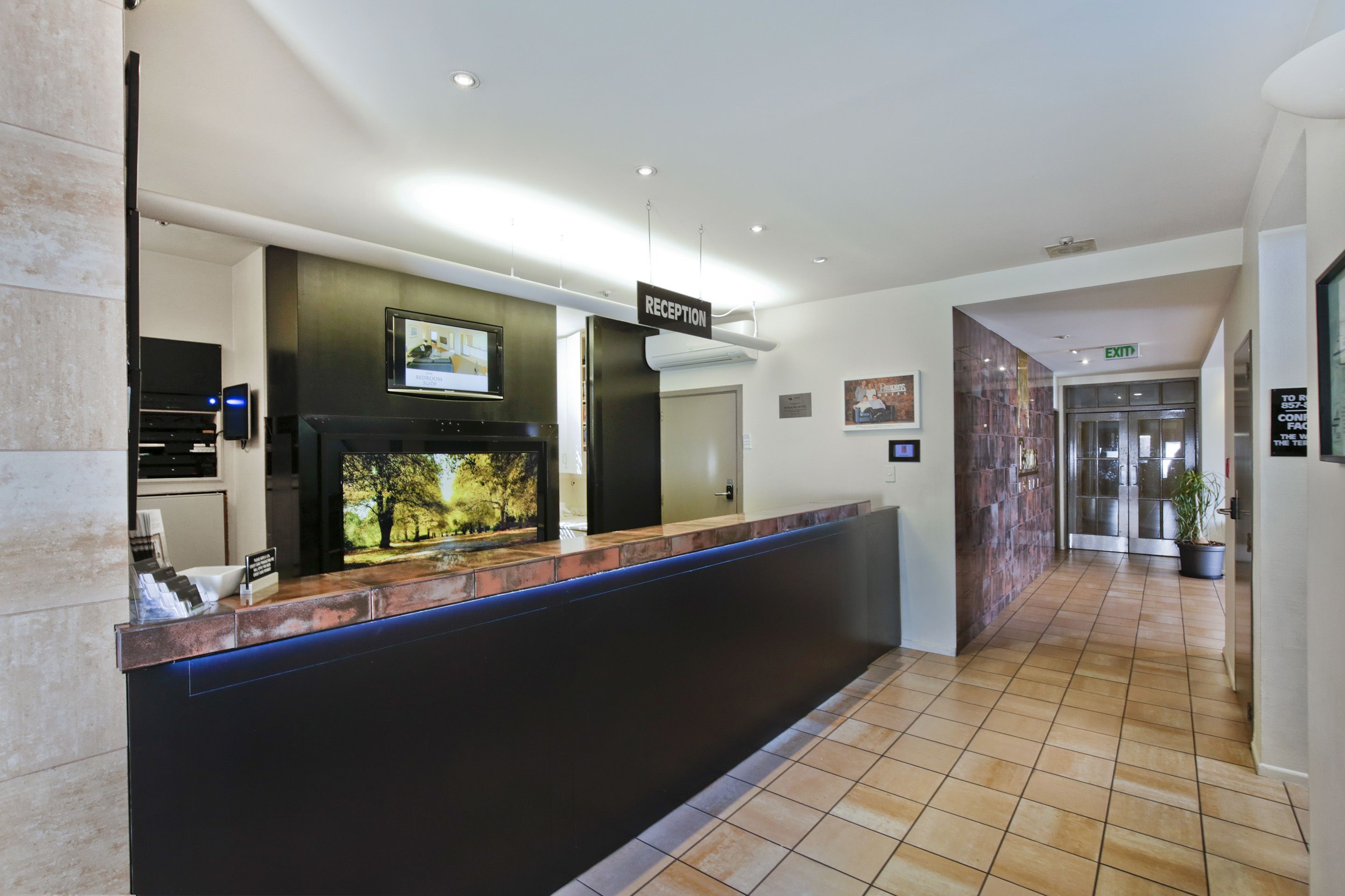 A reception area with a reception desk, a television, and a sign indicating the reception.
