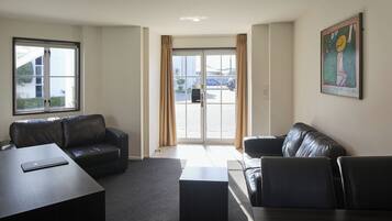 A modern hotel lobby with a leather sofa, a coffee table, and a desk.