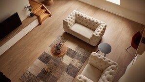 A modern living room with a sofa, a coffee table, and a TV. - Van Der Valk Hotel Dennenhof (Brasschaat)