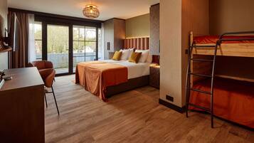 Une chambre d’hôtel avec un lit, un bureau, une chaise, un lit superposé et une grande fenêtre.