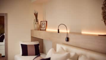 Une chambre à coucher bien rangée, avec un lit, une table de chevet et une étagère ornée d’objets décoratifs.