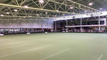 An indoor sports court with a high ceiling and multiple levels of seating.
