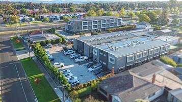 A multi-story building with a parking lot in front.