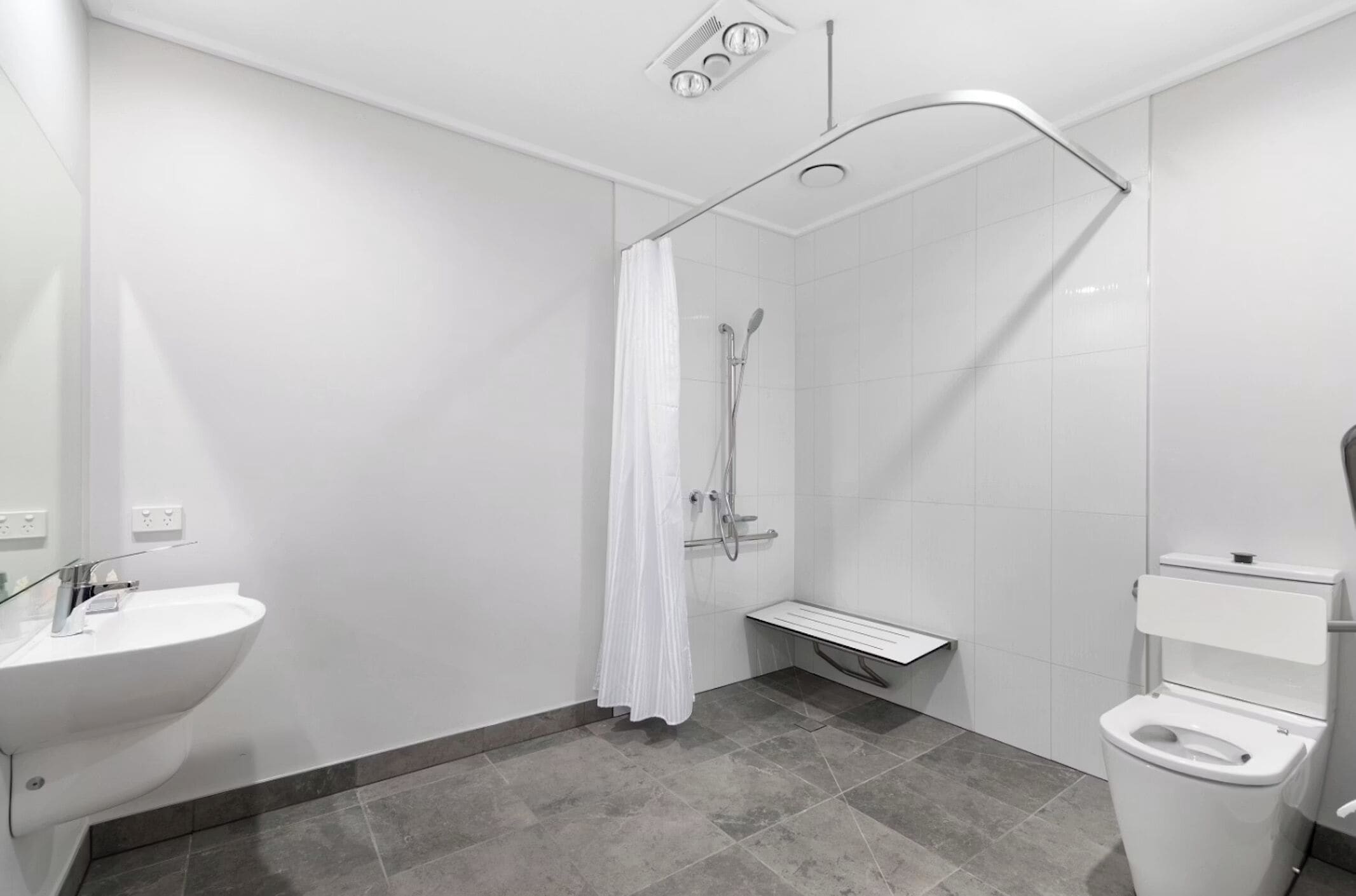 Une salle de bain moderne équipée d’une douche, de toilettes et d’un lavabo.