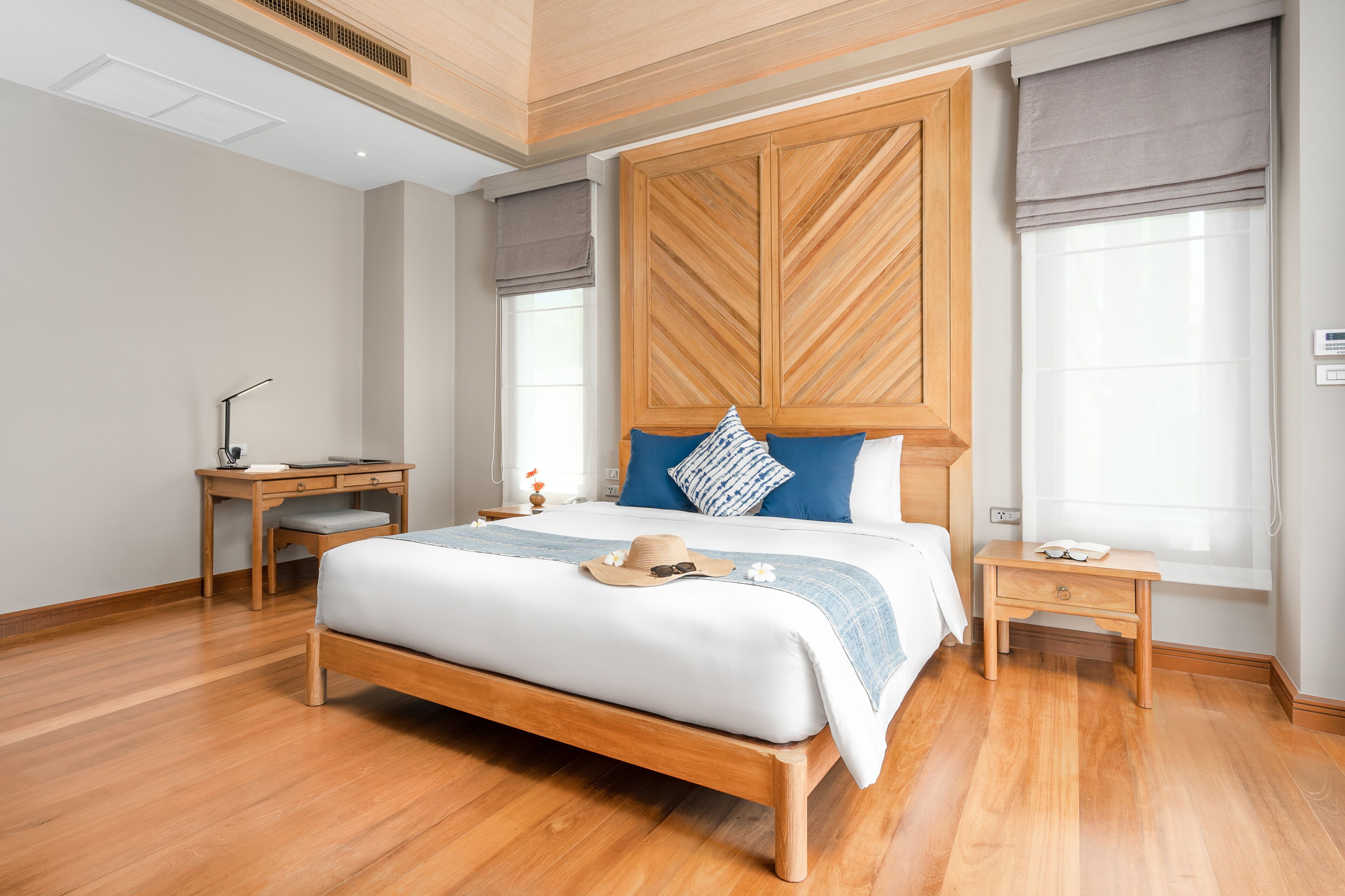 A bedroom with a wooden bed, a desk, and a nightstand.