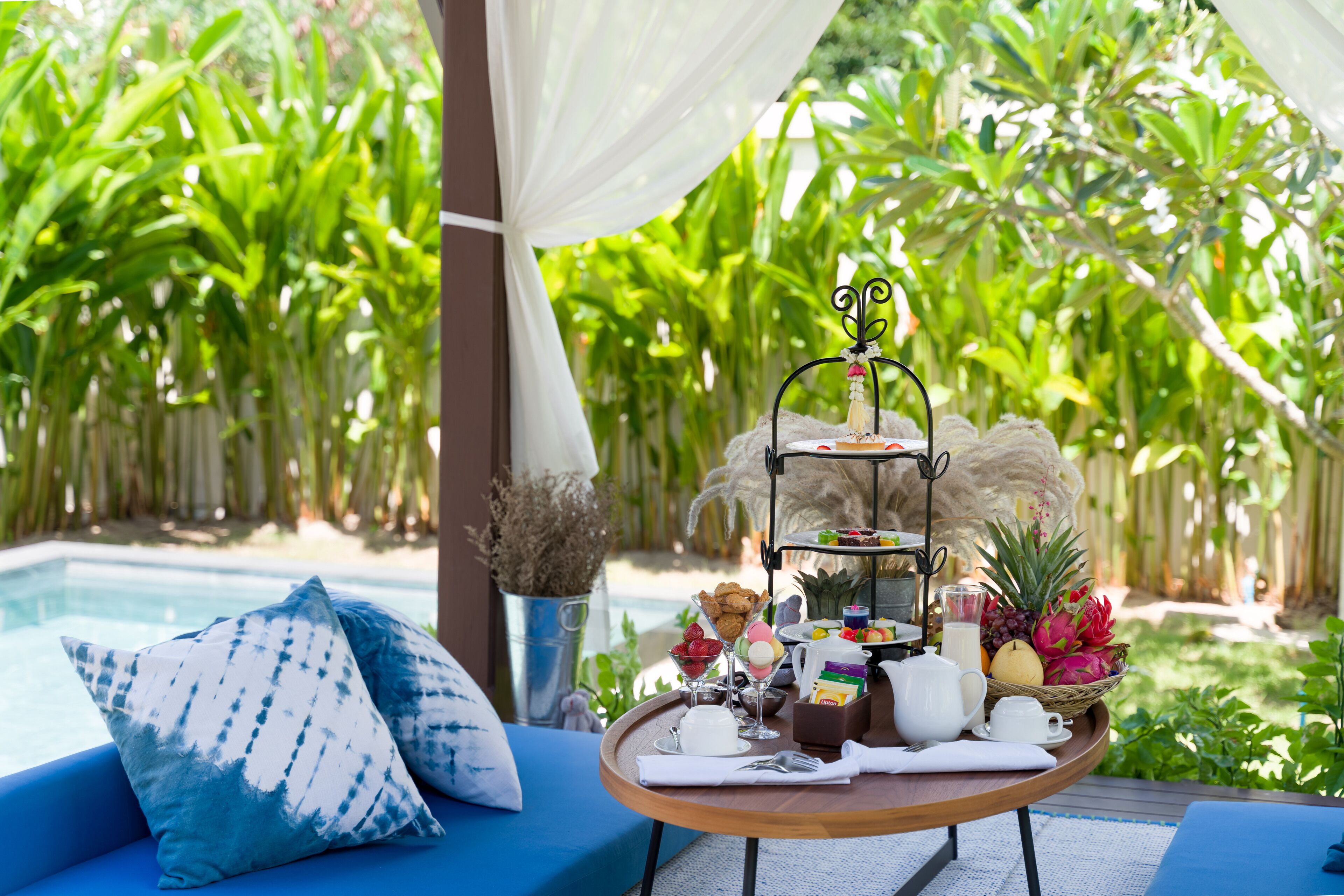 A breakfast table with a tiered stand, fruits, and a decorative item.