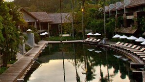 A resort with thatched-roof bungalows, a central pool, and lounge chairs with umbrellas. - The Dewa Koh Chang (Ko Chang)