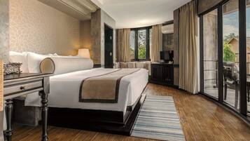 A hotel room with a bed, a desk, a television, and a balcony with a view.