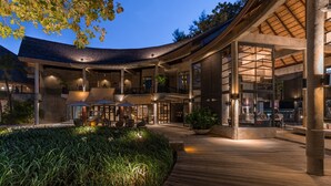 A modern building with a curved roof, outdoor seating area, and a well-lit entrance. - The Dewa Koh Chang (Ko Chang)