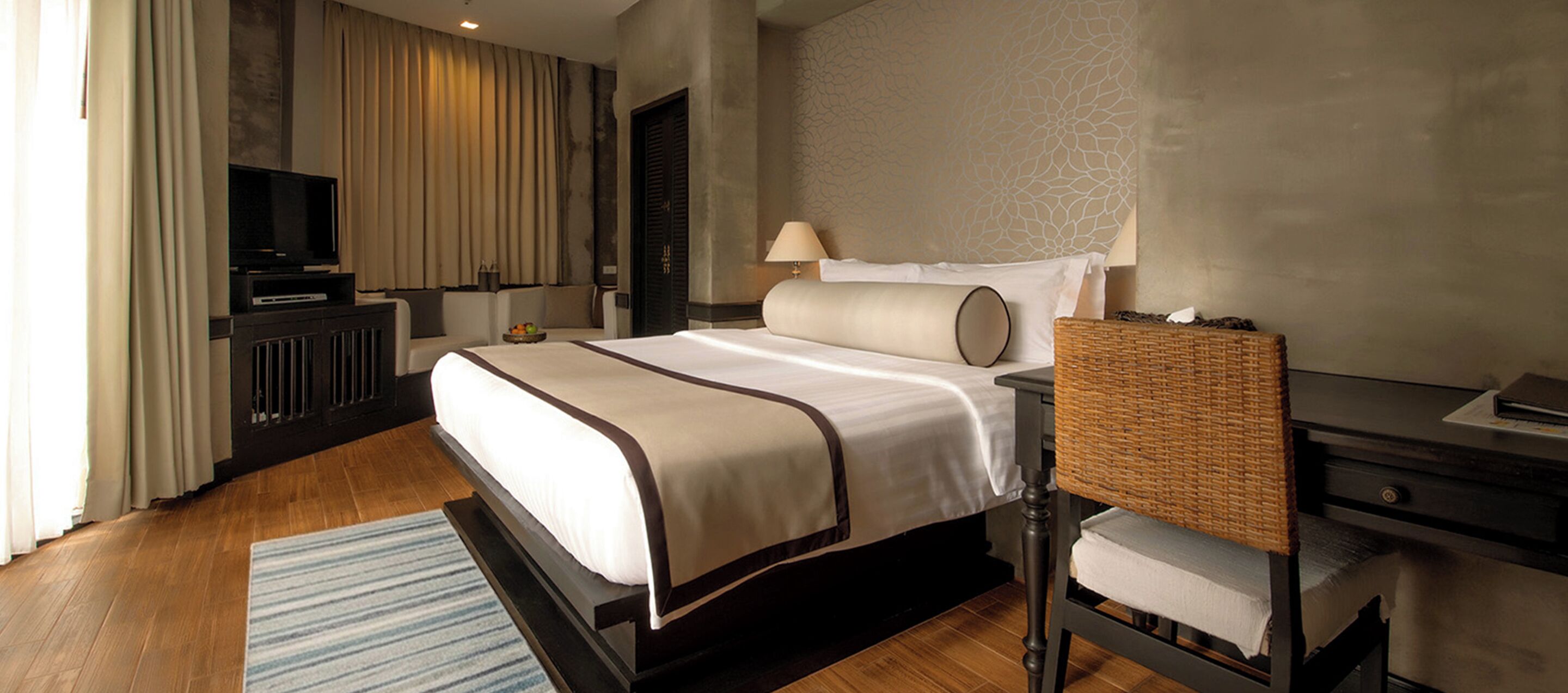 Une chambre d’hôtel équipée d’un lit, d’une télévision, d’une lampe, d’une chaise et d’un bureau.