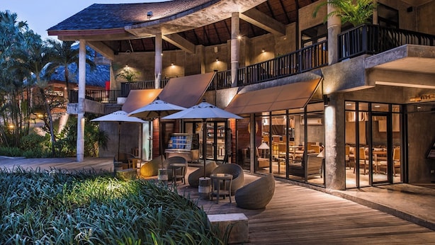 A modern hotel with a spacious outdoor area featuring a wooden deck, comfortable seating, and large umbrellas. - The Dewa Koh Chang (Ko Chang)