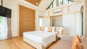 Een moderne hotelkamer met een groot bed, een bank, een nachtkastje en een grote spiegel. Er is een raam met gordijnen en een houten plafond.