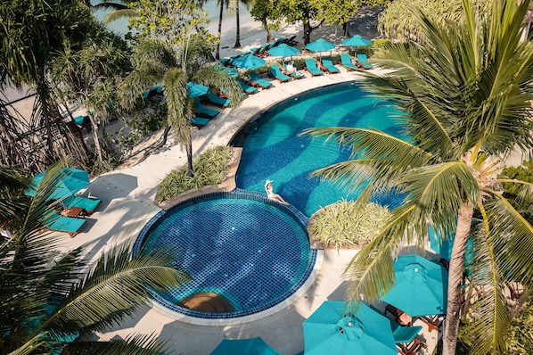 Una piscina al aire libre, sombrillas, tumbonas