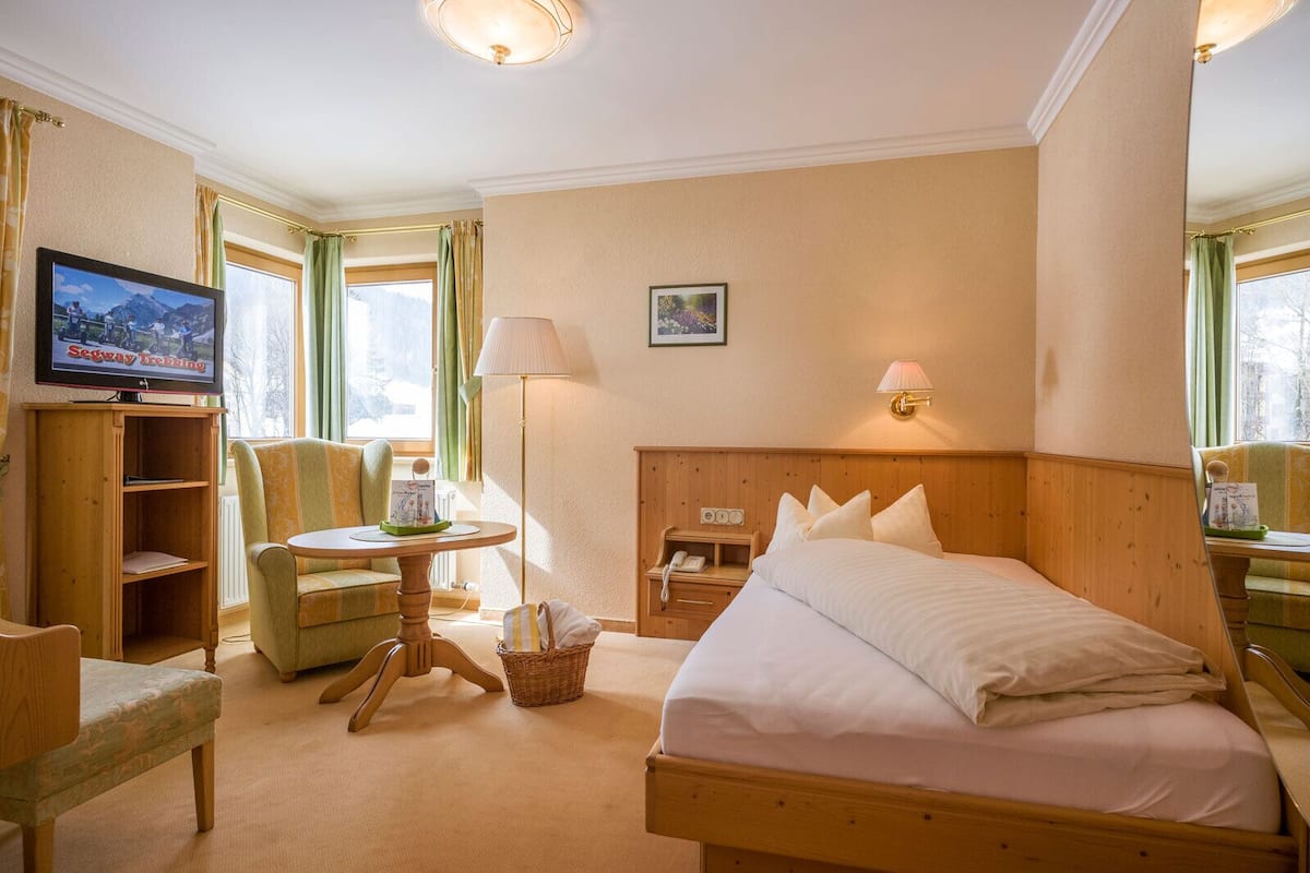 Ein Hotelzimmer mit einem Bett, einem Fernseher, einem Schreibtisch, einem Stuhl und einer Lampe.