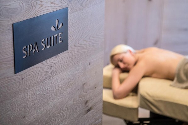 A spa suite sign on a wooden wall.