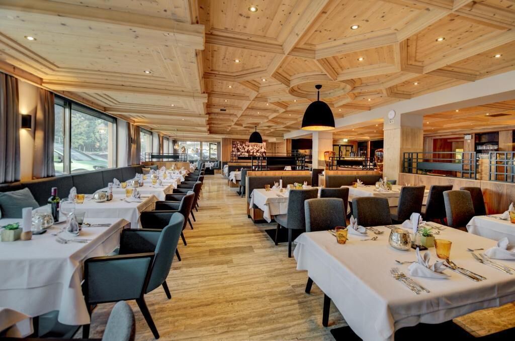 Un restaurante con techo de madera y mesas dispuestas para comer.