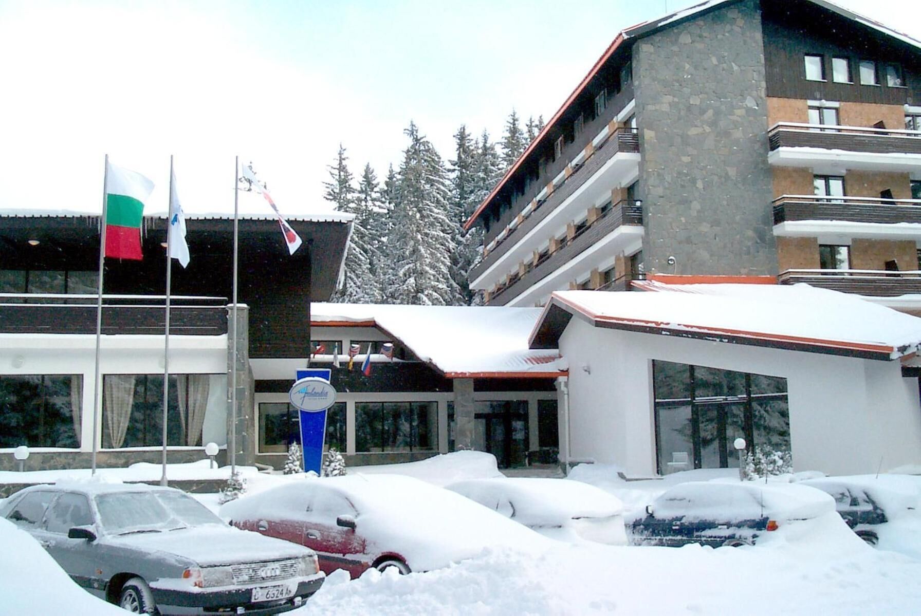 A hotel with multiple floors, a snow-covered parking area, and flags on the building.