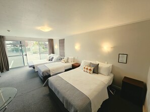 Ein Hotelzimmer mit zwei Betten, einem Schreibtisch und Blick ins Freie.