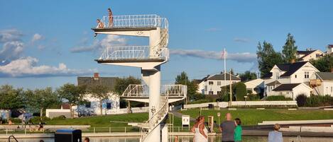 A public park with a diving platform, a swimming area, and a bicycle.