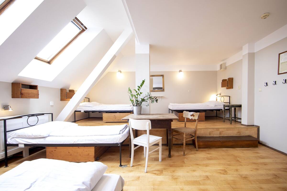 A compact, modern room with two bunk beds, a small desk, and a chair.