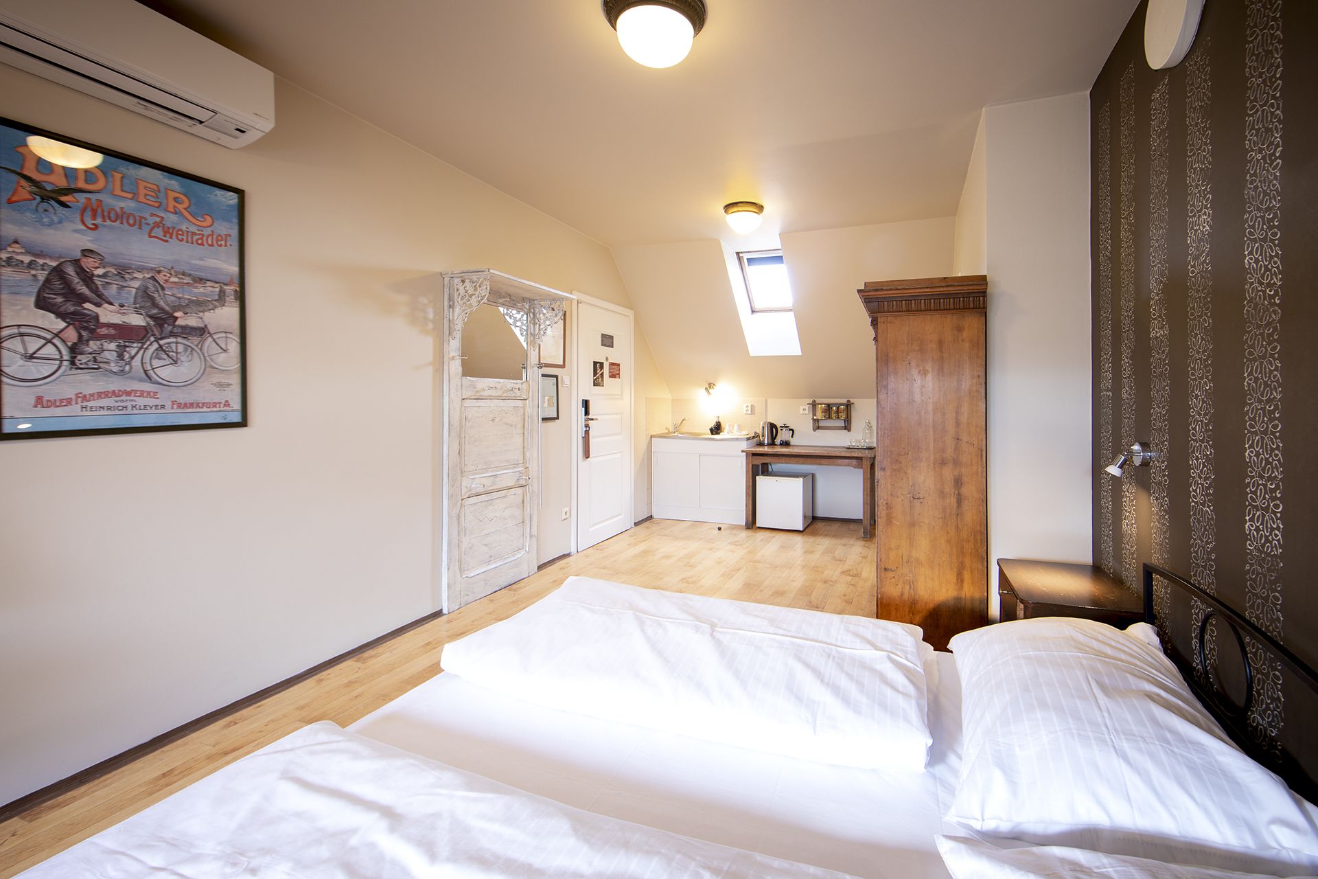 A bedroom with a bed, a desk, and a bathroom in the background.