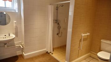 A bathroom with a sink, mirror, shower, and toilet.