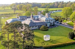 A large estate with multiple buildings, a well-maintained lawn, and a gazebo.