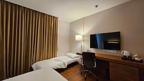 A hotel room with a bed, a desk, a chair, a television, and a lamp. - Sachas Hotel Uno Asoke Sukhumvit Bangkok (Bangkok)