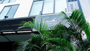 A hotel sign with the name 'Chic Hotel' in front of a modern building with large windows. - Sachas Hotel Uno Asoke Sukhumvit Bangkok (Bangkok)