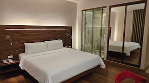 A hotel room with a wooden headboard, a large mirror, and a red chair. - Sachas Hotel Uno Asoke Sukhumvit Bangkok (Bangkok)