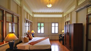 A room with a large bed, wooden wardrobe, and a desk with a chair. - Baan Bayan Beach Hotel (Hua Hin)