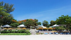 A resort with a covered seating area, a pool, and a staircase leading to a building. - Baan Bayan Beach Hotel (Hua Hin)