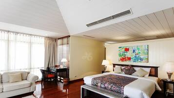 A hotel room with a bed, bedside tables, a desk, a chair, and a large window with curtains.