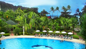 Una piscina al aire libre, sombrillas, tumbonas