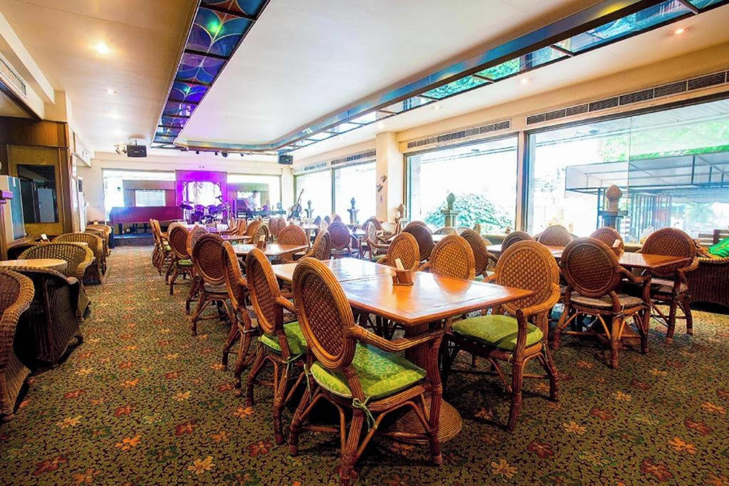 A spacious dining area with wicker furniture and large windows.