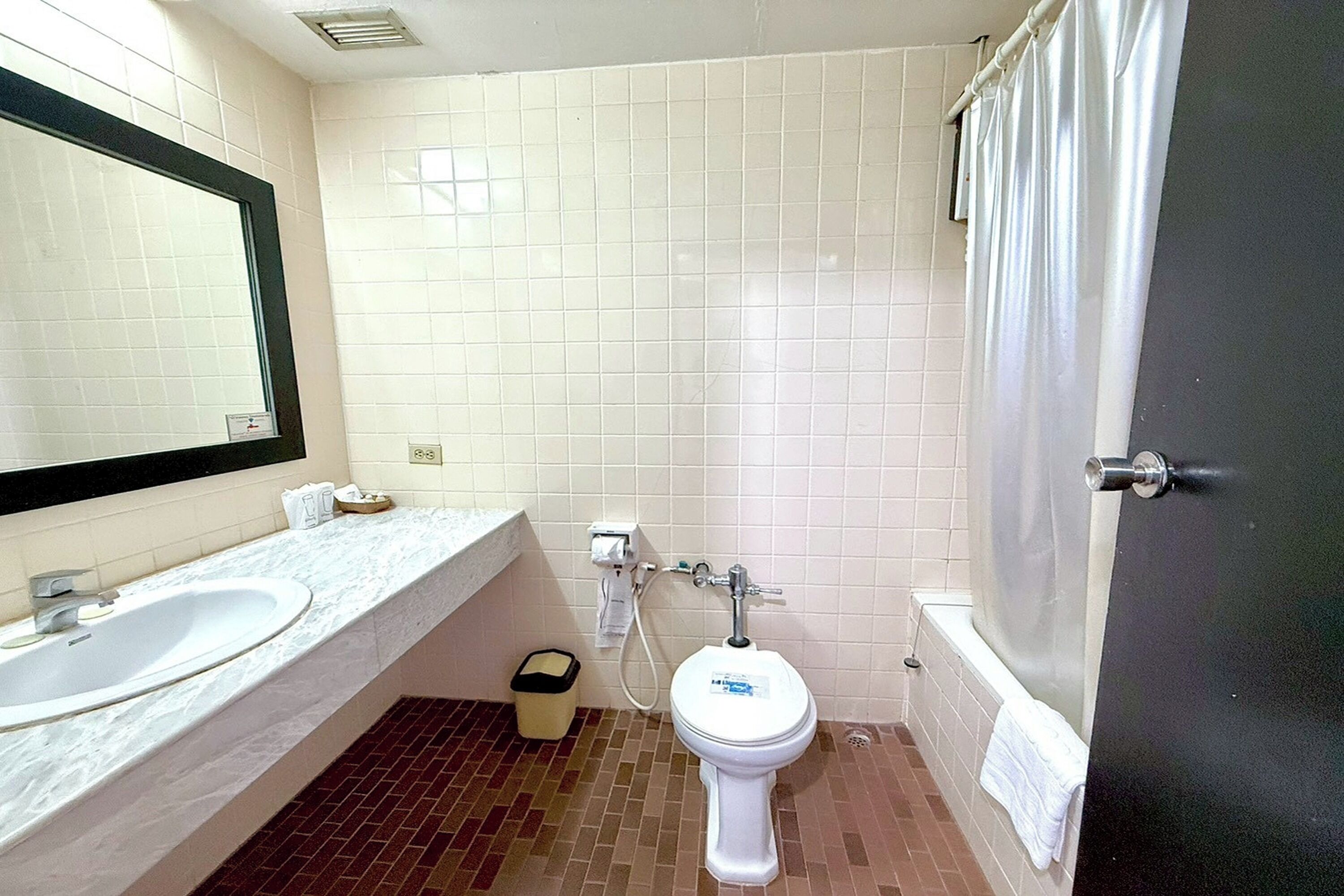A bathroom with a white sink, a toilet, and a shower curtain.