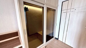 A room with a sliding glass door closet, a wooden floor, and a white wardrobe. - Pailyn Hotel Phitsanulok (Phitsanulok)